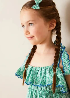 Pepa London Adelaide Floral Tiered Tie Strap Dress in Green (4-12yrs) | Plain Cardigan in Navy (6mths-10yrs) | Metallic Strappy Leather Sandals in Gold (24-35EU) | Adelaide Floral Detail Raffia Bag in Green | Adelaide Floral Small Bow Hair Clip in Green