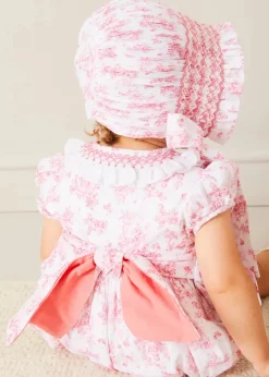 Pepa London Audrey Hand Smocked Double Breasted Short Sleeve Romper in Pink (6mths-2yrs) | Audrey Toile Hand Smocked Bonnet in Pink (S-M) | Openwork Cotton Cardigan in Pink (6mths-10yrs) | Mary Jane Pram Shoes in Pink (17-20EU) | Openwork short socks White (0mths-8yrs)