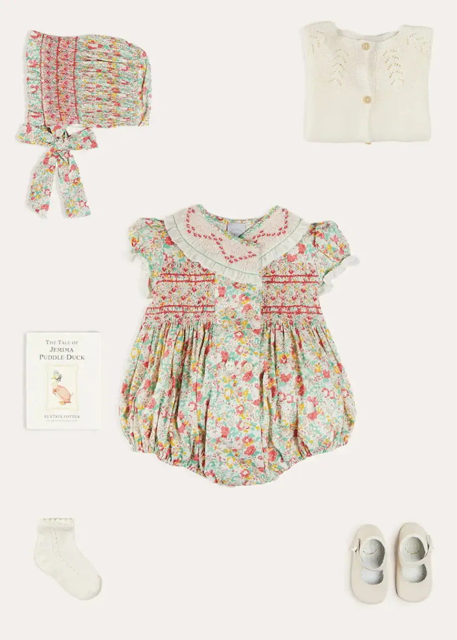 Pepa London Clementine Floral Hand Smocked Double Breasted Short Sleeve Romper in Coral (6mths-3yrs) | Clementine Floral Hand Smocked Bonnet in Coral (S-M) | Openwork Cotton Cardigan in Cream (6mths-10yrs) | Leather Mary Jane Pram Shoes in Ivory (17-20EU) | Openwork short socks White (0mths-8yrs)