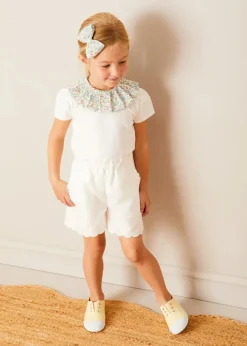Pepa London Cordelia Floral Collar Top in Pink Made with Liberty Fabric (2-10yrs) | Scallop Trim Embroidered Shorts in White (2-10yrs) | Floral Openwork Cotton Cardigan in Pink (2-10yrs) | Canvas Plimsolls in Cream (20-35EU) | Cordelia Floral Medium Bow Clip in Pink Made with Liberty Fabric | The Tale Of Kitty In Boots Book in White