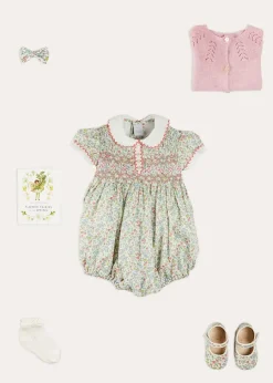 Pepa London Cordelia Floral Hand-Smocked Short Sleeve Romper in Pink Made with Liberty Fabric (3m-2yrs) | Openwork Cotton Knitted Bonnet in Pink (S-L) | Openwork Cotton Cardigan in Pink (6mths-10yrs) | Cordelia Liberty Floral Mary Jane Pram Shoes in Pink (17-20EU) | Flower Fairies of the Spring Book in White | Cordelia Floral Small Bow Clip in Pink Made with Liberty Fabric | Openwork short socks White (0mths-8yrs)