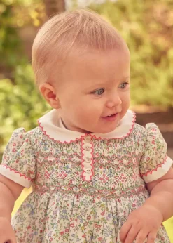 Pepa London Cordelia Floral Hand-Smocked Short Sleeve Romper in Pink Made with Liberty Fabric (3m-2yrs) | Openwork Cotton Knitted Bonnet in Pink (S-L) | Openwork Cotton Cardigan in Pink (6mths-10yrs) | Cordelia Liberty Floral Mary Jane Pram Shoes in Pink (17-20EU) | Flower Fairies of the Spring Book in White | Cordelia Floral Small Bow Clip in Pink Made with Liberty Fabric | Openwork short socks White (0mths-8yrs)