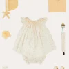 Pepa London Esme Floral Hand Smocked Sleeveless Dress With Bloomers in White (1-12mths) | Openwork Detail Cotton Baby Cardigan in Tangerine (1-12mths) | Lace Detail Knitted Bonnet in Tangerine (1-12mths) | Celebration Ribbon Detail Mary Jane Pram Shoes in Beige (17-20EU) | Esme Floral Dummy Clip in White | Openwork short socks White (0mths-8yrs) | Chick Toy in Yellow | BIBS Dummy in Sage Green