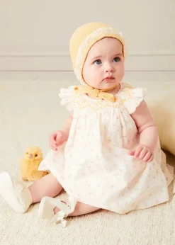 Pepa London Esme Floral Hand Smocked Sleeveless Dress With Bloomers in White (1-12mths) | Openwork Detail Cotton Baby Cardigan in Tangerine (1-12mths) | Lace Detail Knitted Bonnet in Tangerine (1-12mths) | Celebration Ribbon Detail Mary Jane Pram Shoes in Beige (17-20EU) | Esme Floral Dummy Clip in White | Openwork short socks White (0mths-8yrs) | Chick Toy in Yellow | BIBS Dummy in Sage Green