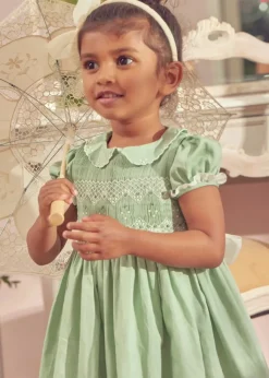 Pepa London Hand Smocked Peter Pan Collar Short Sleeve Dress in Green (12mths-10yrs) | Openwork Cotton Cardigan in Cream (6mths-10yrs) | Girls Ivory Leather Mary Jane Shoes (20-34EU) | Traditional Big Bow Tulle Hairband in Ivory | Flower Fairies of the Spring Book in White | Openwork short socks White (0mths-8yrs)