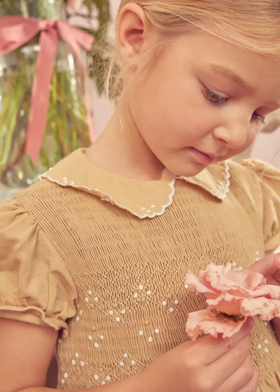 Pepa London Hand Smocked Peter Pan Collar Short Sleeve Dress in Beige (12mths-10yrs) | Openwork Cotton Cardigan in Cream (6mths-10yrs) | Mary Jane Leather Baby Shoes in Ivory (20-24EU) | Traditional Big Bow Tulle Hairband in Ivory | Celebration Short Socks with Ruffle- Cream (0mths-10yrs)