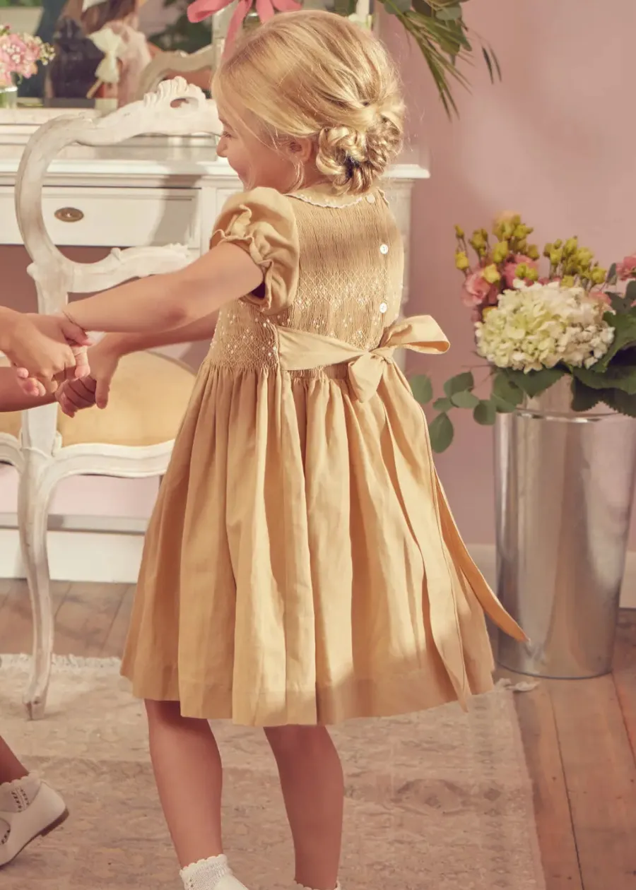 Pepa London Hand Smocked Peter Pan Collar Short Sleeve Dress in Beige (12mths-10yrs) | Openwork Cotton Cardigan in Cream (6mths-10yrs) | Mary Jane Leather Baby Shoes in Ivory (20-24EU) | Traditional Big Bow Tulle Hairband in Ivory | Celebration Short Socks with Ruffle- Cream (0mths-10yrs)