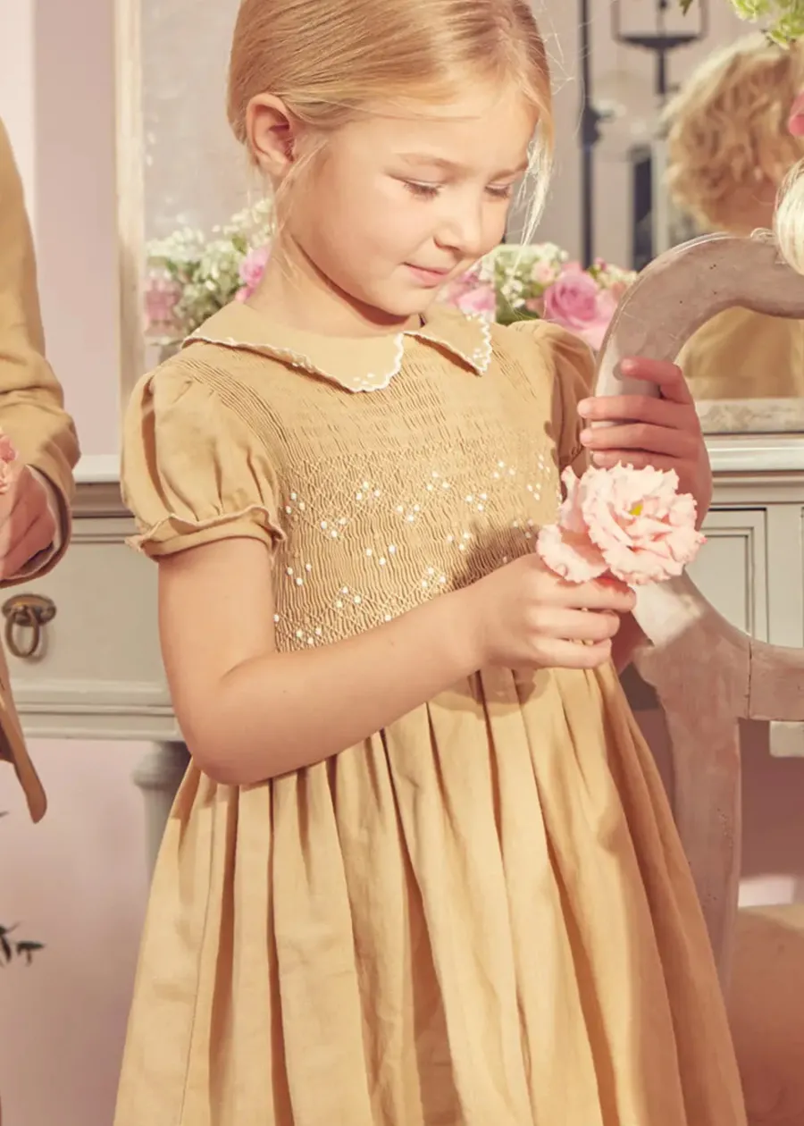 Pepa London Hand Smocked Peter Pan Collar Short Sleeve Dress in Beige (12mths-10yrs) | Openwork Cotton Cardigan in Cream (6mths-10yrs) | Mary Jane Leather Baby Shoes in Ivory (20-24EU) | Traditional Big Bow Tulle Hairband in Ivory | Celebration Short Socks with Ruffle- Cream (0mths-10yrs)