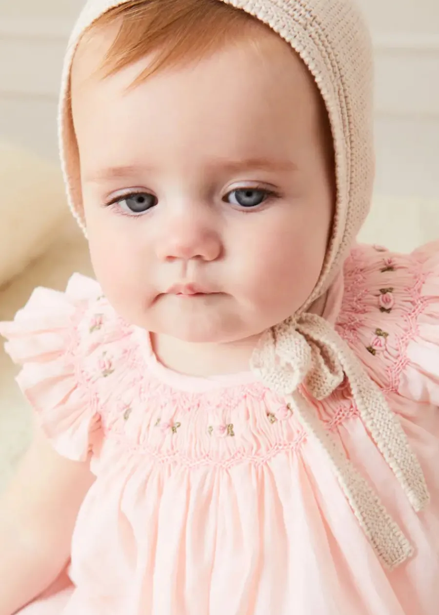 Pepa London Hand Smocked Sleeveless Dress With Bloomers in Pink (1-12mths) | Openwork Detail Baby Cardigan in Pink (1-12mths) | Openwork Knitted Bonnet in Beige(S-L) | Cordelia Liberty Floral Mary Jane Pram Shoes in Pink (17-20EU) | Cordelia Liberty Floral Dummy Clip in Pink | Knitted Bunny Teether in Beige | BIBS Dummy in Pink