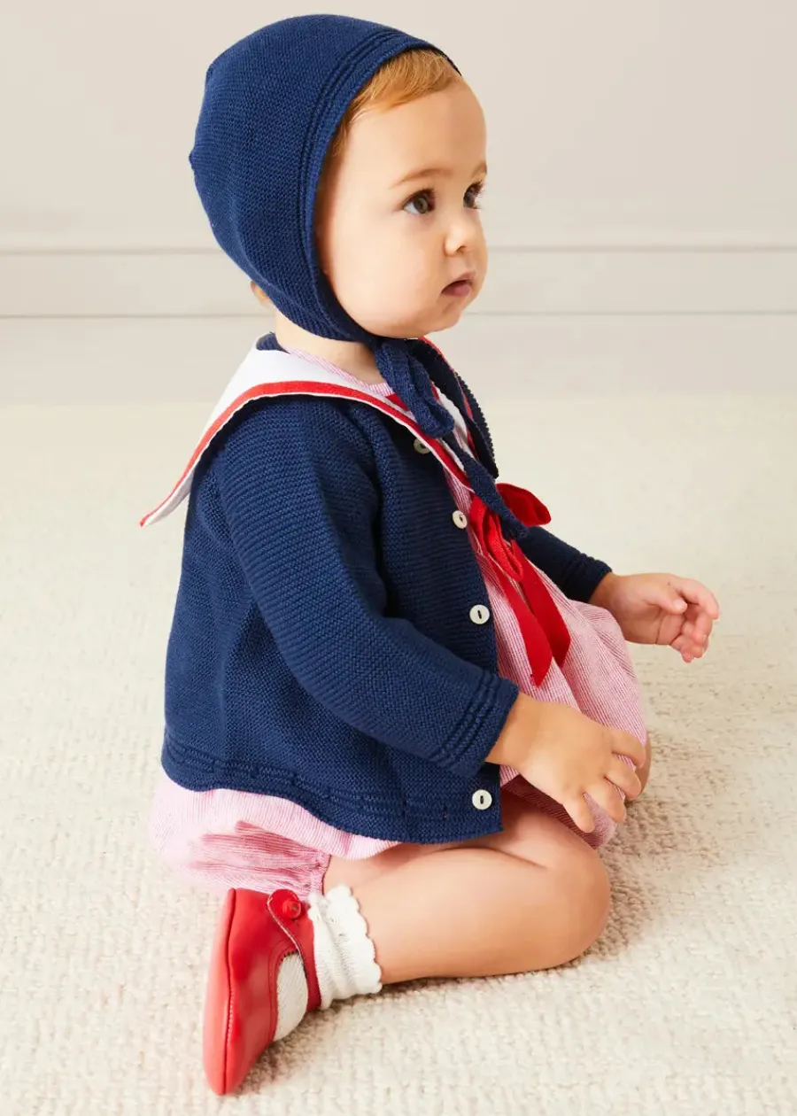Pepa London Lawrence Striped Mariner Collar Short Sleeve Romper in Red (6mths-3yrs) | Openwork Knitted Bonnet in Navy (S-L) | Plain Cardigan in Navy (6mths-10yrs) | Leather Mary Jane Pram Shoes in Red (17-20EU) | Openwork short socks White (0mths-8yrs)