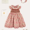 Pepa London Margot Hand-Smocked Dress in Red Made with Liberty Fabric (12m-6yrs) | Openwork Cotton Cardigan in Cream (6mths-10yrs) | Mary Jane Leather Baby Shoes in Ivory (20-24EU) | Margot Liberty Floral Scrunchie Hairband in Red | Openwork short socks White (0mths-8yrs)