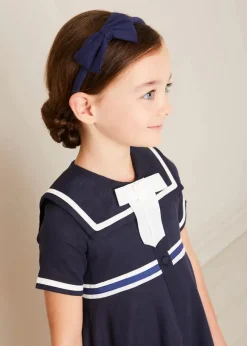Pepa London Mariner Collar Bow Detail Short Sleeve Dress in Navy (4-12yrs) | Plain Cardigan in Navy (6mths-10yrs) | Girls Ivory Leather Mary Jane Shoes (20-34EU) | Navy Linen Big Bow Hairband | Cotton Short Socks Cream (0mths-10yrs)