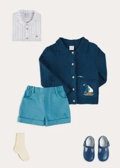 BOY Pepa London Nautical Boat Embroidery Polo Collar Cardigan in Blue (12mths-6yrs) | Chesham Striped Mao Collar Long Sleeve Shirt in Red (3-10yrs) | Plain Elasticated Shorts in Blue (12mths-4yrs) | T-Bar Baby Shoes in Blue (20-26EU) | Ribbed Short Socks in Beige (0mths-10yrs)