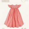 Pepa London Plain Hand Smocked Sleeveless Dress in Coral (12mths-10yrs) | Plain Cardigan in Cream (6mths-10yrs) | Girls Ivory Leather Mary Jane Shoes (20-34EU) | Traditional Big Bow Tulle Hairband in Ivory | Openwork short socks White (0mths-8yrs)